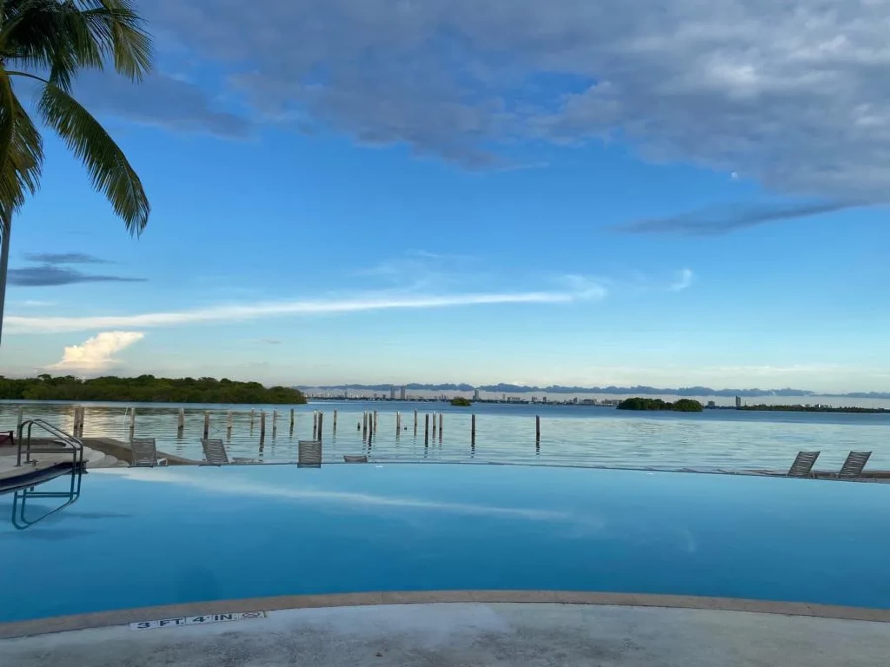 Infinity-edge pool at dusk with bay views